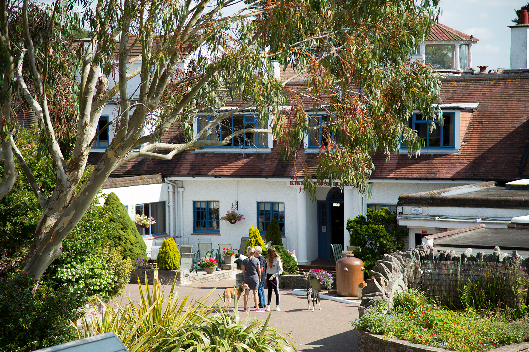 A family and dogs stand in the grounds of a dog-friendly hotel in Dorset